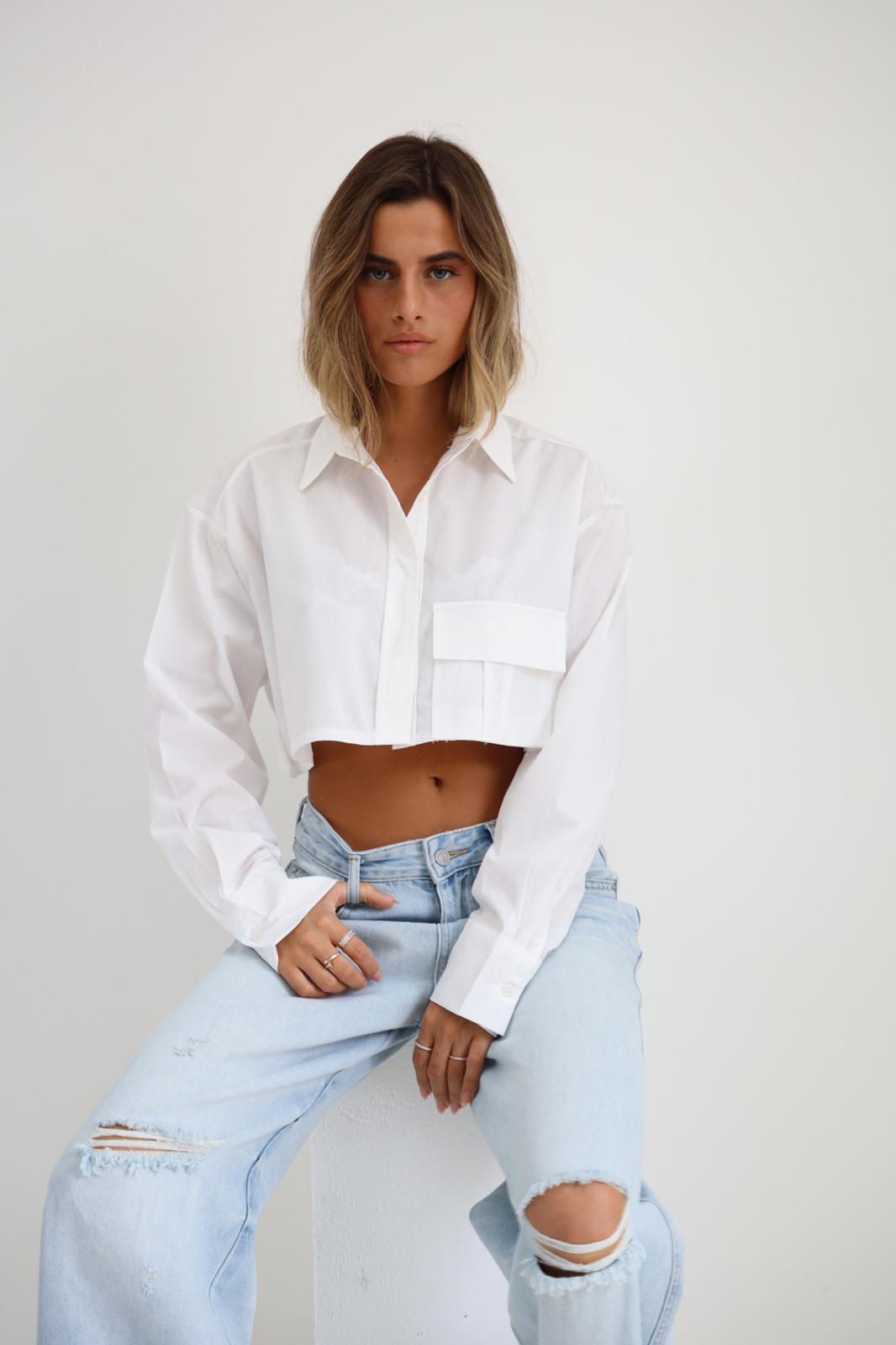 חולצת Mor לבנה בגזרת קרופ מכופתרת עם צווארון קלאסי וכיס קדמי בשילוב ג׳ינס בהיר